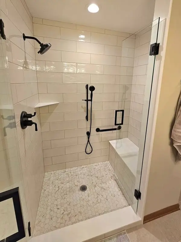 Tiled shower with a corner seat, grab bar and handheld sprayer