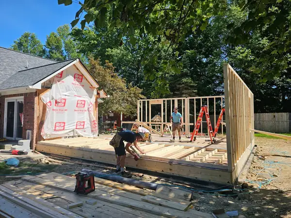 Crew framing an exterior wall on a new floor deck