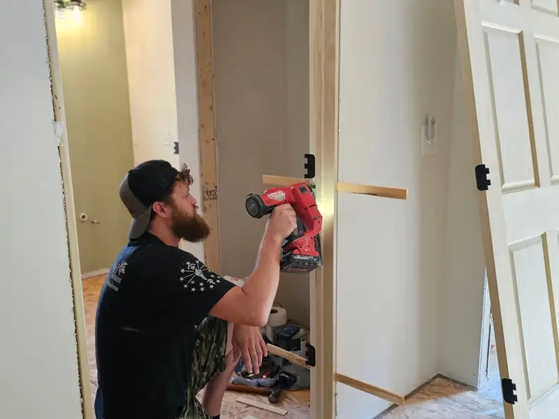 Carpenter fitting a new interior door during a whole-home renovation