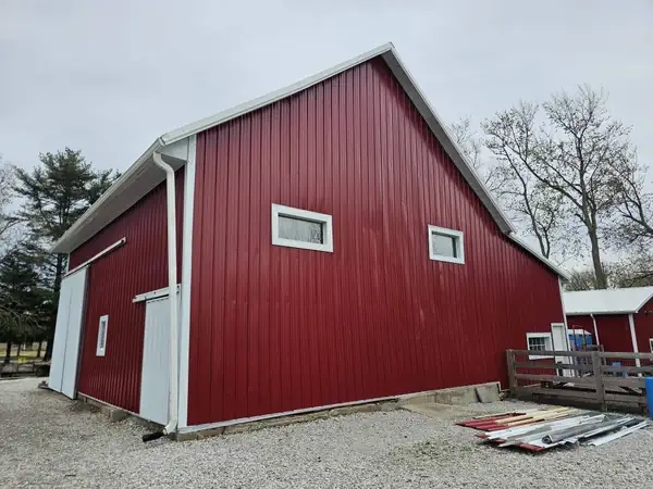 Red pole barn with white trim on a rural Indiana property
