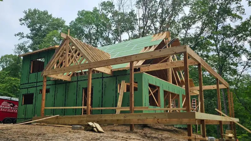 Timber-framed custom home under construction on a wooded Indiana lot