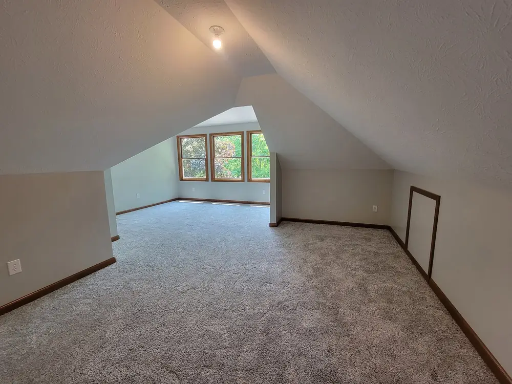 Finished bonus room with dormer windows and new carpet above a garage