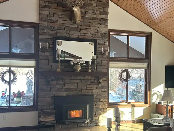 Floor-to-ceiling stone fireplace under a vaulted pine ceiling