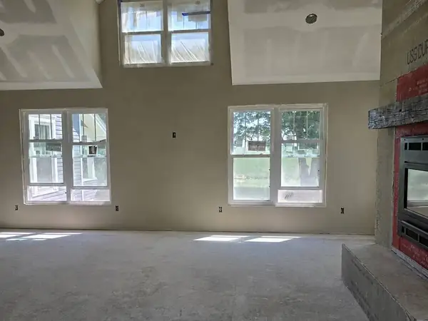 Vaulted room at the drywall stage with a fireplace opening framed