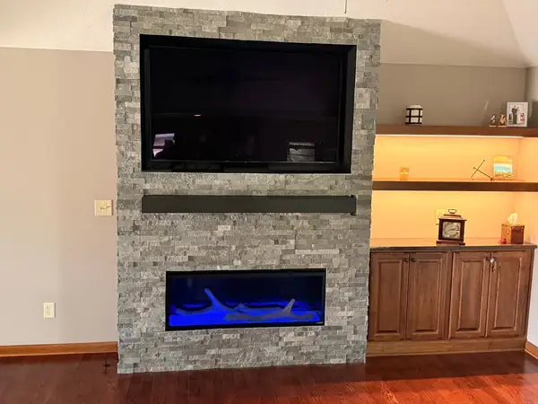 Linear gas fireplace with a stone surround and built-in cabinetry