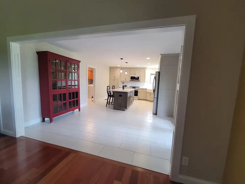 Wall opened between a dining room and a remodeled kitchen, with new flooring running through