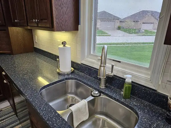 Undermount double sink in dark granite with a gooseneck faucet