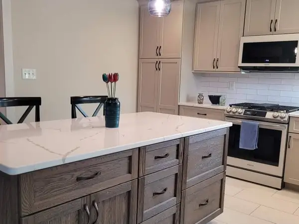 Kitchen with a gray stained island and tile flooring