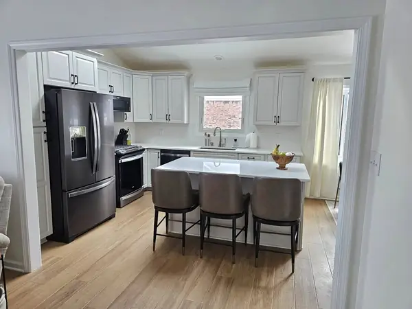 Long kitchen island with pendant lighting and bar stools