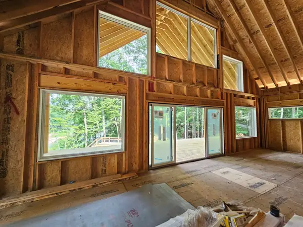 Framed interior with exposed timber and a wall of new windows