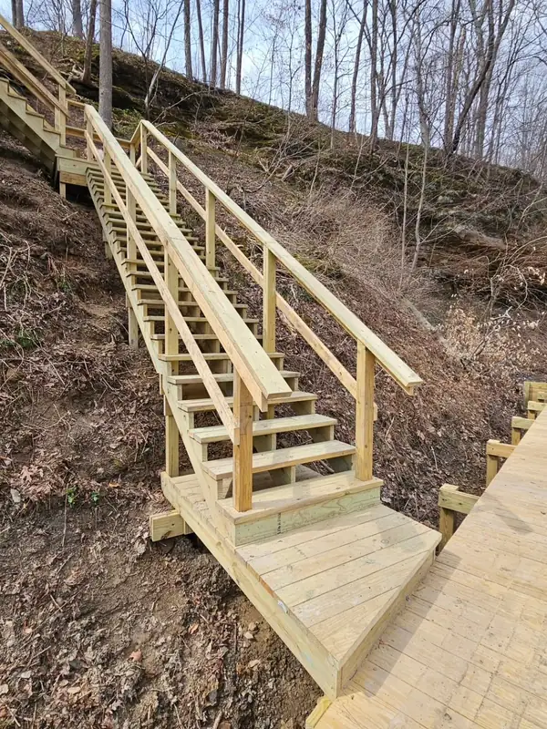 Timber staircase descending a wooded cliff toward the shoreline