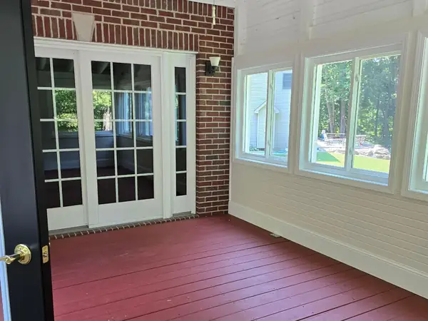 Newly stained porch decking under a shiplap ceiling
