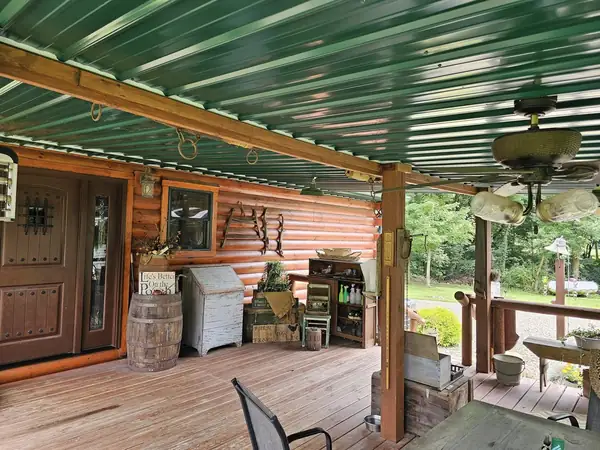 Covered porch with a wood ceiling, fans and railing