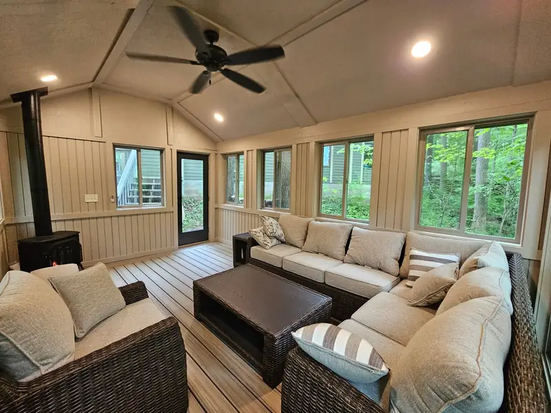 Finished four-season room addition with a vaulted ceiling and wraparound windows