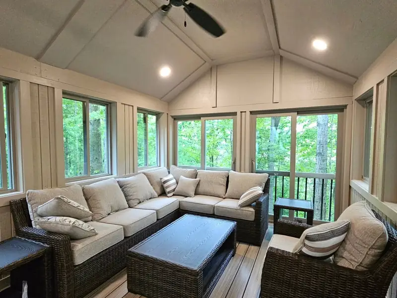 Finished four-season sunroom addition with a vaulted ceiling and a wall of windows