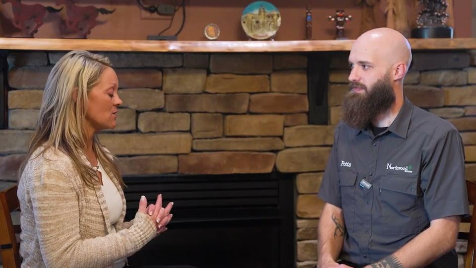 An American Dream TV host interviewing a Northwood Homes builder in front of a stone fireplace